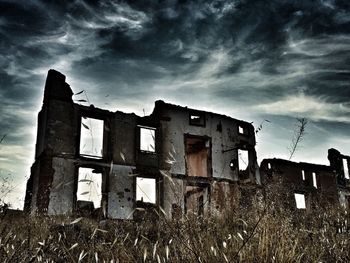 Low angle view of old ruin against cloudy blue sky