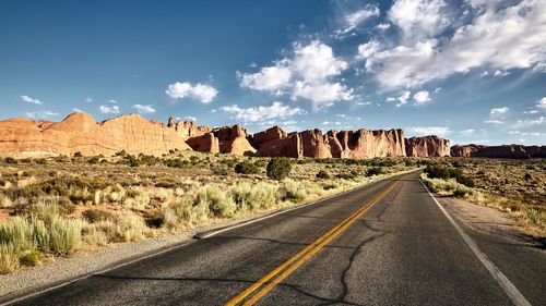 Road amidst rocks against sky