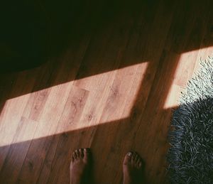 Low section of man standing on hardwood floor