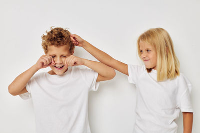 Cute sibling fighting against white background