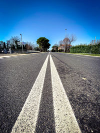 Surface level of road against blue sky