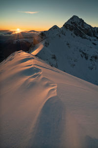 Scenic view of snowcapped mountains against sky during sunset