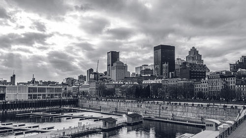 Buildings in city against cloudy sky