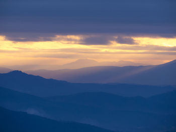 Scenic view of silhouette mountains against sky during sunset