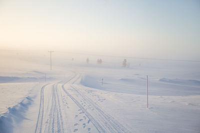 Snow covered road against sky during winter