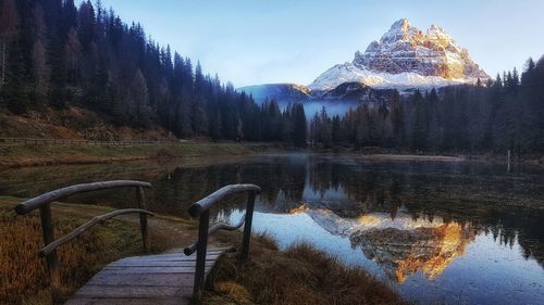 Reflection of snowcapped mountain in lake at forest