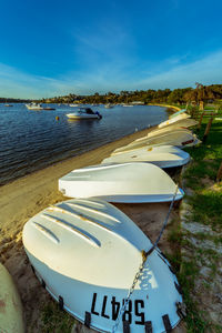 Boats moored on beach against sky