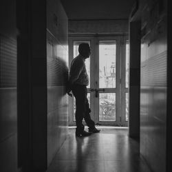 Side view of man standing in corridor of building