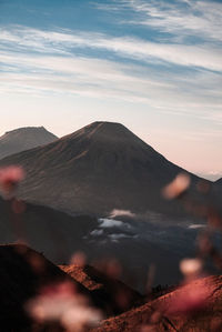 Scenic view of volcanic mountain against sky during sunset