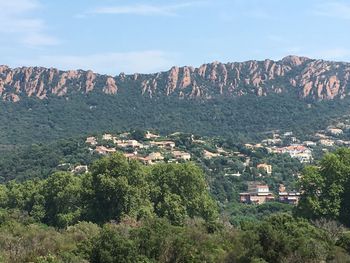 Aerial view of townscape by mountain against sky