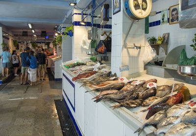 Shoppers and vendors at a fish market in the traditional mercado in tarifa, spain.