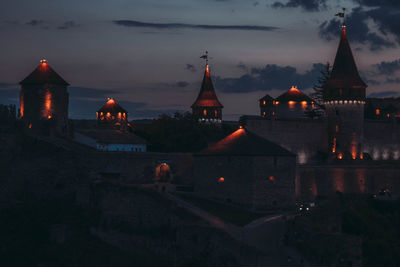 Illuminated building against sky at dusk