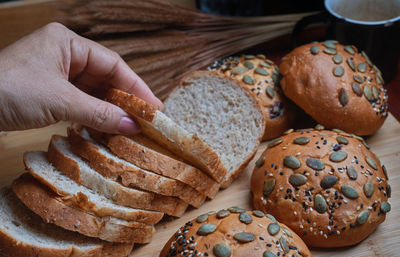 Close-up of hand holding bread on table
