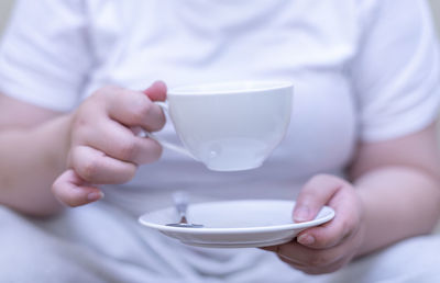 Midsection of man holding coffee