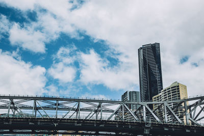 Low angle view of skyscraper against cloudy sky