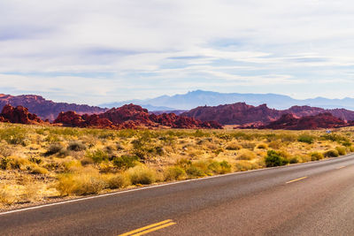 Road by mountains against sky