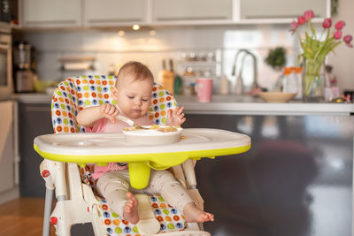 Cute baby eating food at home