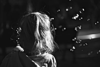 Rear view of woman in illuminated christmas lights