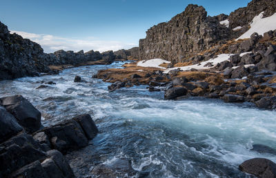 Rocks in sea against sky