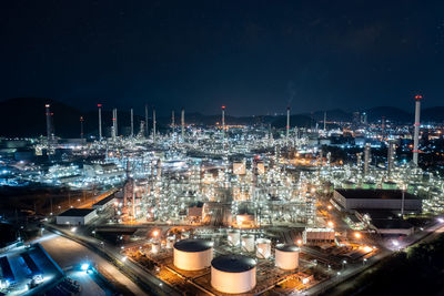 Chemical industry storage tank and oil refinery in industrial plant at night over lighting star