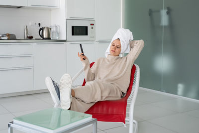 Woman sitting on chair at home