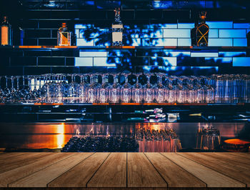 Wooden table in front of abstract blurred restaurant lights background of bar