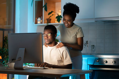 Loving wife support freelance web designer husband working on small business project from home late