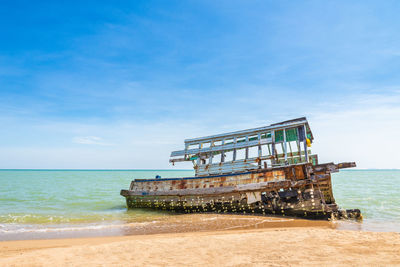 Lifeguard hut on beach against sky