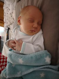 Close-up of baby boy on bed