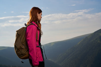 Rear view of woman standing against mountain