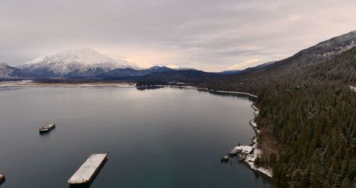 Scenic view of lake by mountains against sky