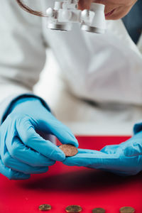 Hands of ancient coins valuation expert researching value of coins