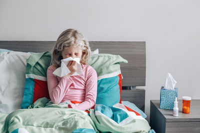 Woman sitting on bed at home
