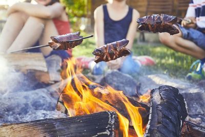 Friends preparing food in bonfire