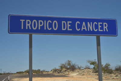 Road sign against clear blue sky