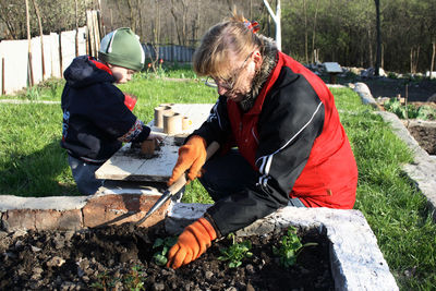 Mother and son gardening in yard