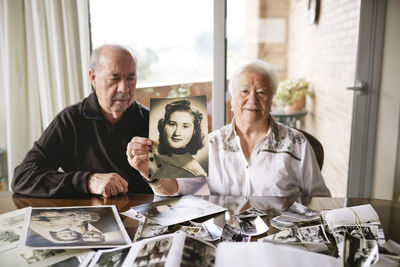 Senior woman showing an old picture of herself