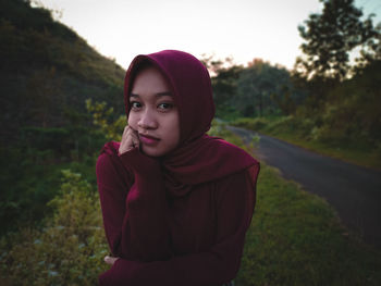 Portrait of young woman standing on field