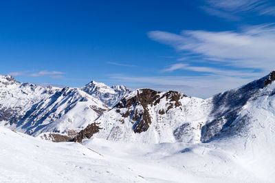 Scenic view of snowcapped mountains against blue sky winter sport