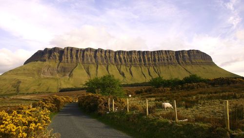 Road leading towards mountain against sky