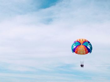 Low angle view of person paragliding against sky