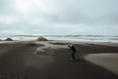 Man standing on beach against sky