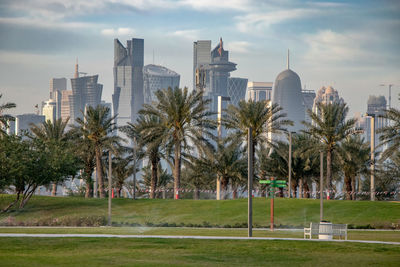 View of trees and buildings against cloudy sky