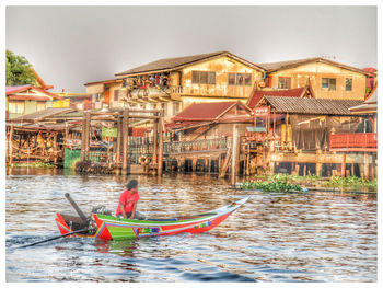 Boats in river against buildings