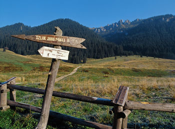 Information sign on landscape against sky