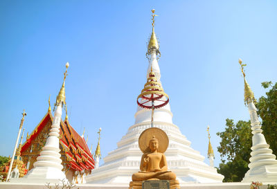 Seated buddha image and mantra with group of mon style pagoda, wat chomphuwek temple, thailand