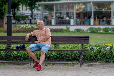 Portrait of mature man sitting on bench in park
