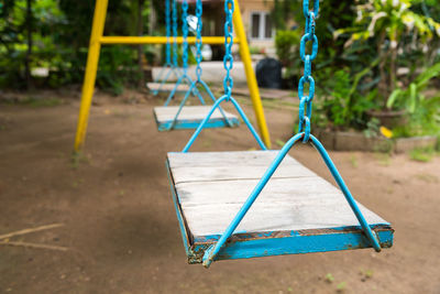 Empty swings hanging in park