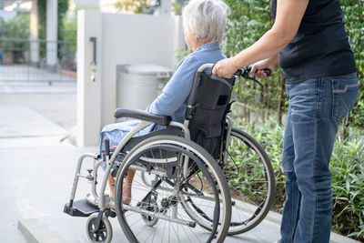 Caregiver help and care asian senior or  woman patient sitting on wheelchair 