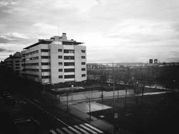 Buildings in city against cloudy sky